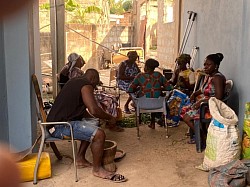 Patients that are almost fully recovered pounding the herbs for their treatment locally